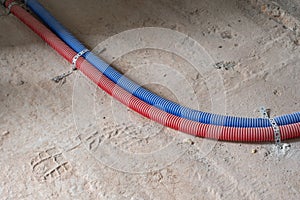 Blue and red plastic corrugated tubes stretched across the floor