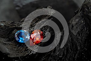 Blue and red sapphir on black coal background photo