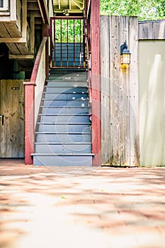 Blue and Red Staircase Outdoors with a Glowing Lamp Beside