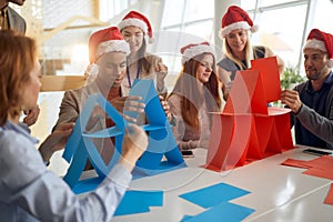 Blue and red team competing in building card towers at the office for christmas