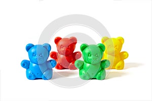 Blue, red, yellow and green plastic toy bears isolated on white background arranged in two rows