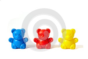 Blue, red and yellow plastic toy bears isolated on white background