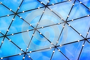 Blue reflections of clouds in glass trianles of transparent roof