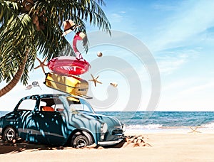 Blue retro car with luggage and pink flamingo on beautiful tropical beach. Summer travel concept background.
