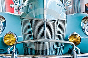 Blue retro car with yellow headlamps