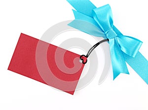 blue ribbon with simple tied bow wrapped gift box corner with blank red cardboard tag card for greeting message