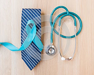 Blue ribbon symbolic for prostate cancer awareness and men`s health in November month on necktie, doctor`s stethoscope