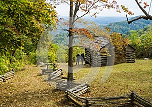 Autumn View Couple by a Log Cabin Overlooking the Valley
