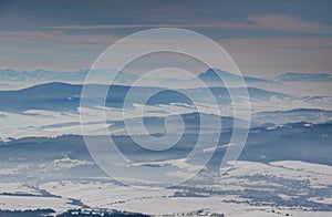 Blue ridges, misty snowy valleys and a conical peak in Slovakia