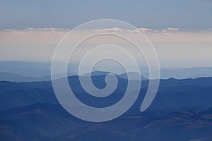 Blue ridges of Slovak Ore Mountains under white clouds