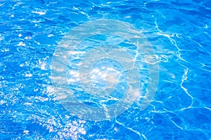 Blue ripped water in swimming pool. background the surface of the water. texture, blue water, bright rays of the sun