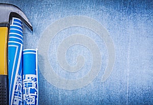 Blue rolled blueprints claw hammer on metallic background copysp photo