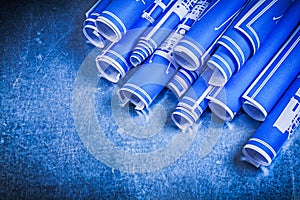 Blue rolled blueprints on metallic background construction conce