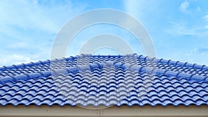 Blue roof tiles arranged on the roof. Hip Roof of the house is beautifully lined.