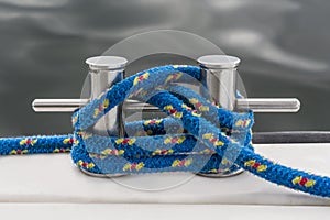 Blue rope fasten on stake of yacht