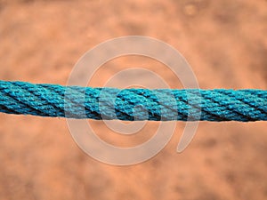 Blue rope on sand background
