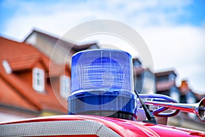 Blue rotating beacon on the roof of a red fire truck