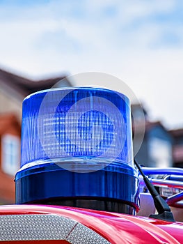 Blue rotating beacon on the roof of a red fire truck