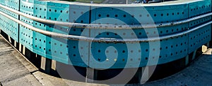 Blue round fence with wholes made of metal.