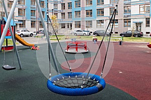 Blue round wicker swing children playground residential community residential buildings exterior background