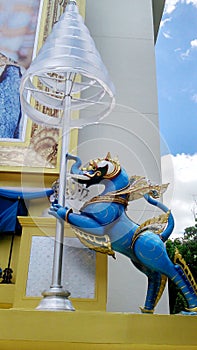 Blue royal lion holding tiered umbrella