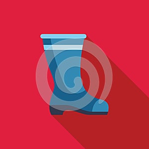 Blue rubber boot standing on a red background
