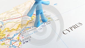 A blue rubber man figurine standing over Ayia Napa on a map of Cyprus