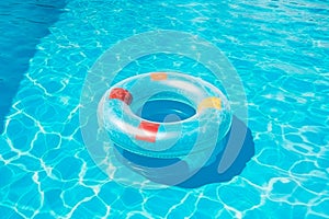 Blue rubber ring float in a refreshing blue swimming pool.