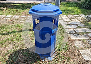 A blue rubbish bin placed in a residential park