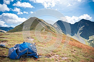 Blue Rucksack and mountain path in the background - trekking equipment, hillwalking gear, mountaineering