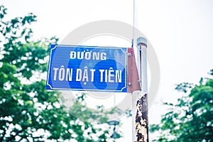 A blue rusted street sign with text on white background