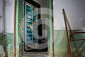 Blue rusty hermetical door of old abandoned Soviet bomb shelter photo