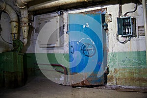 Blue rusty hermetical door of old abandoned Soviet bomb shelter photo