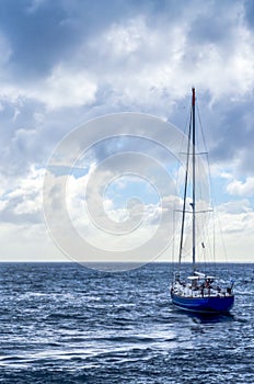 Blue Sailboat at Sea