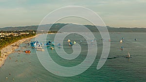 Blue sailboats on the island of Boracay in the evening.