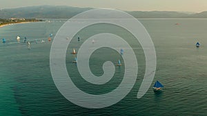 Blue sailboats on the island of Boracay in the evening. Small sailing boats for touristic excursions at sunset in