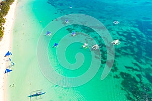 Blue sailing boats off the island of Boracay. Seascape, beautiful lagoon and white beach.