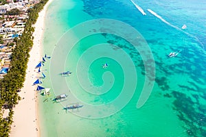 Blue sailing boats off the island of Boracay. Seascape, beautiful lagoon and white beach.