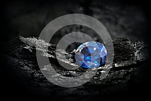 Blue sapphire on black coal background photo