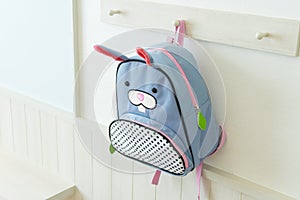 Blue school rucksack hanging on the wall