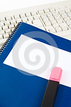 Blue school textbook and computer keyboard