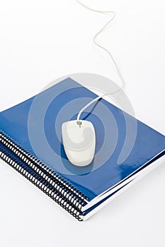 Blue school textbook and computer mouse