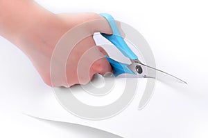 Blue scissors cutting white paper.