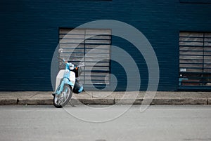 Blue scooter bike against a blue wall