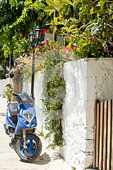 A blue scooter parked at home. Photograph taken at Lefkada Island, Greece