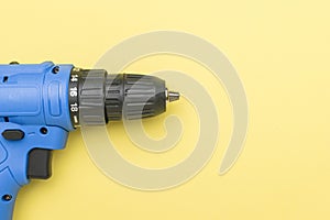 A blue screwdriver on a light yellow background