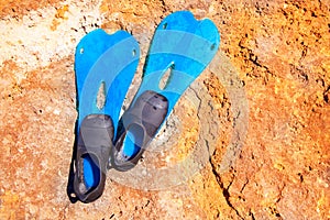 Blue scuba diving fins on summer day over rock
