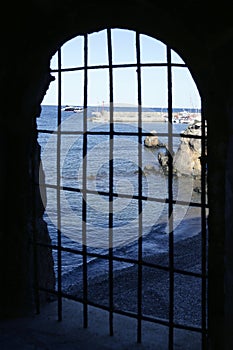 Blue sea behind the jail, arch window