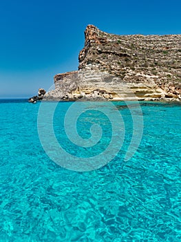 Blue sea and blue sky rocks lampedusa rabbits beach sicily italy meditherranean sea