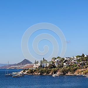 Blue sea, boats, mountains and small town on the coast of the Aegean sea. Summer holidays concept